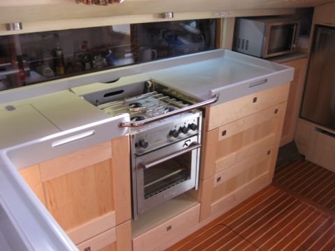 Gimballed cooker integrated into worktop, with cover retracted
